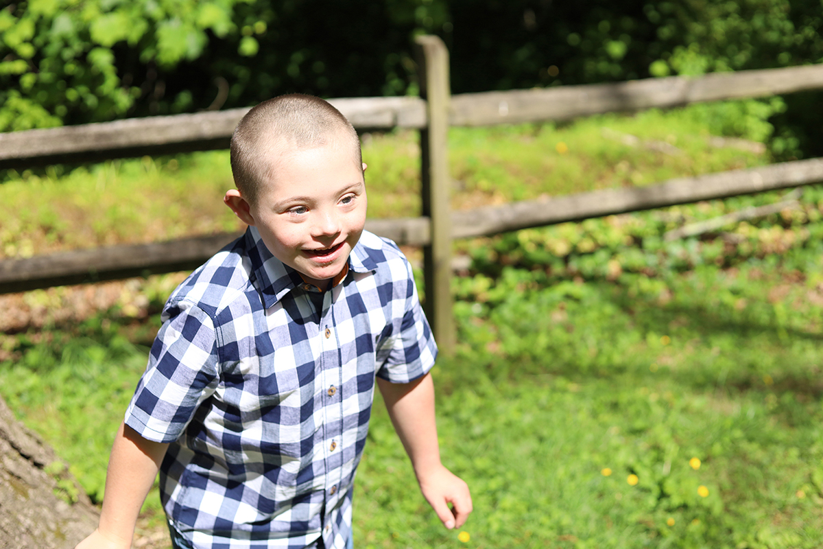 DelcoDSIG - Make a D
 onations Banner - image of a little boy who has Down syndrome running in a
  field